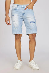 Person wearing light blue denim shorts on a plain background